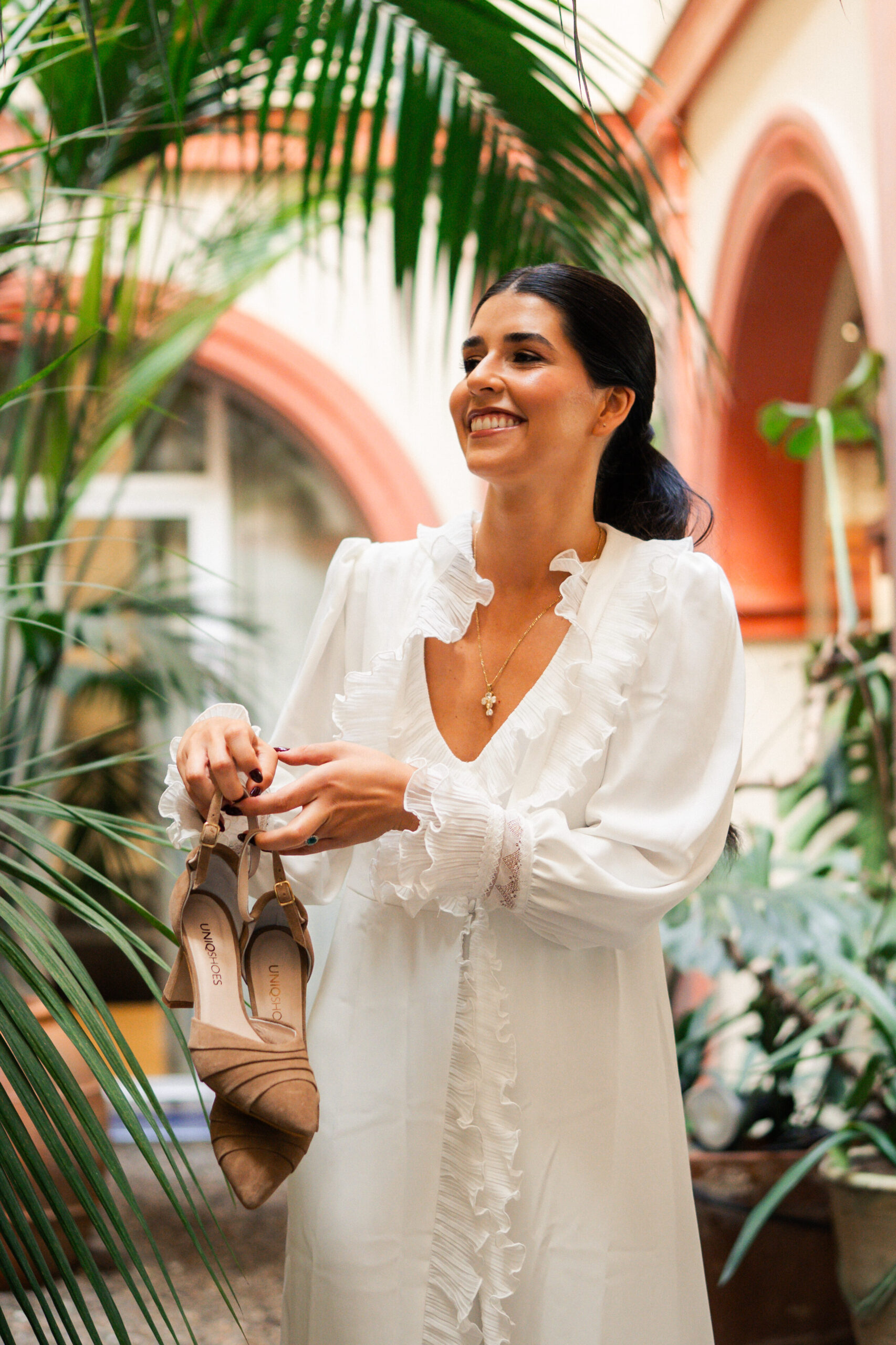 novia sujetando zapatos de novia beige elegantes y cómodos uniqshoes