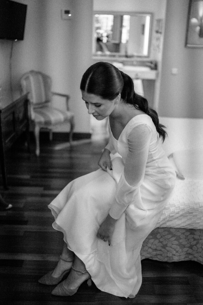 novia con vestido de manga larga y velo largo zapatos de novia elegantes en tonos neutros